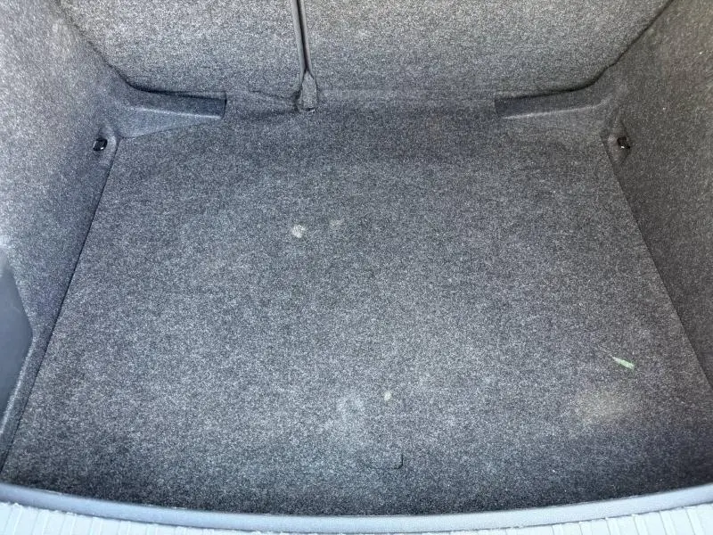 Vue intérieure du coffre spacieux et tapissé de tissu gris du Skoda Scala noir Magic nacré 2025.