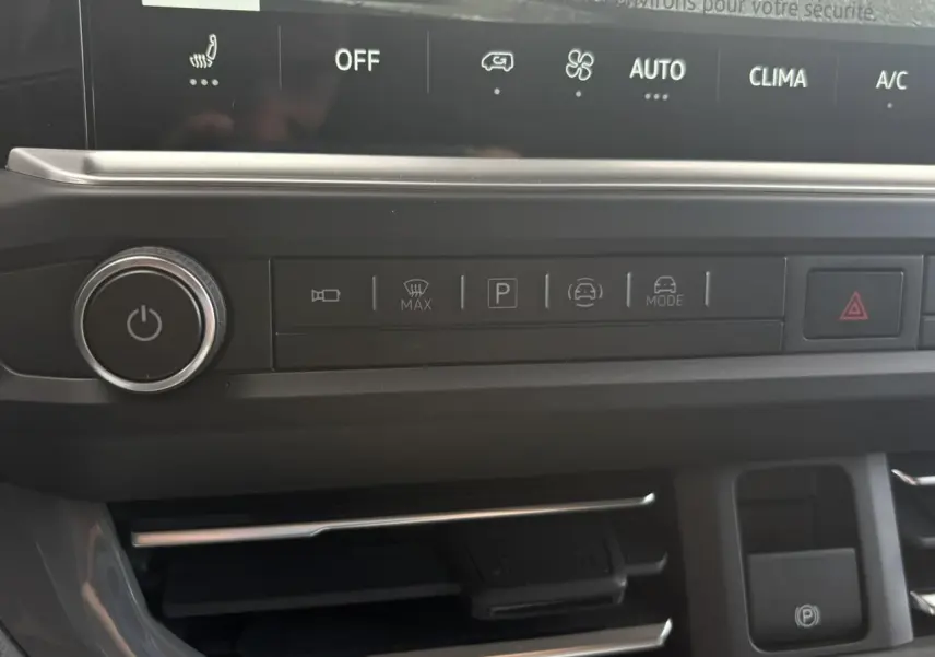 Gros plan sur la console centrale du Volkswagen Transporter T7 ProCab, boutons de commande et écran tactile visibles.