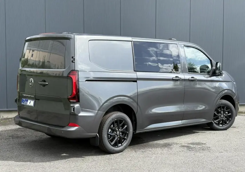 Vue 3/4 arrière droite du Volkswagen Transporter T7 ProCab graphite métallisé avec jantes noires et feux arrière LED.