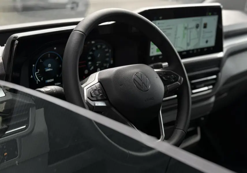 Vue intérieure du volant multifonction noir du Volkswagen Transporter T7 avec tableau de bord numérique et écran tactile.