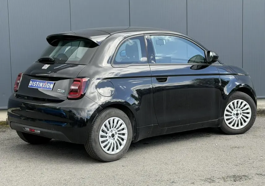 Vue 3/4 arrière droite d'une FIAT 500 électrique 2024 en noir Onyx avec jantes blanches et feux arrière LED.
