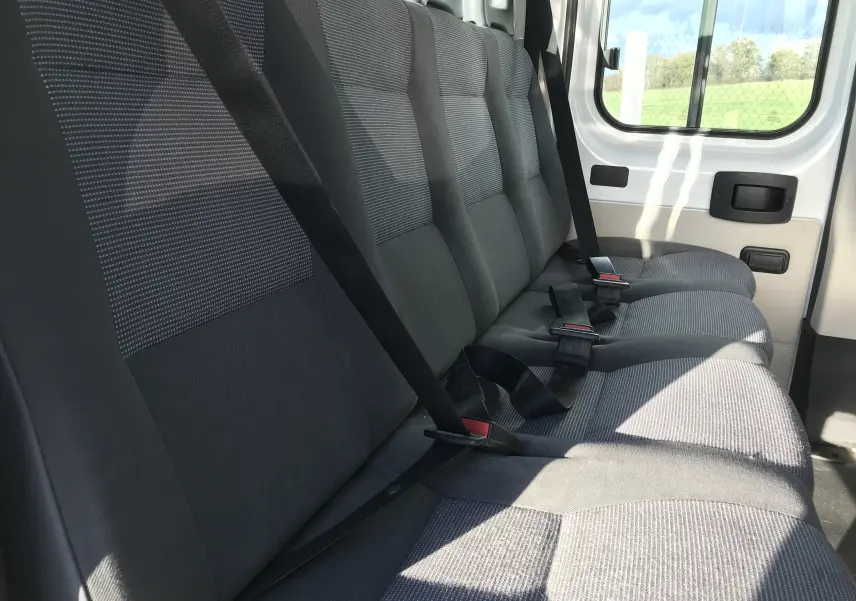 Banquette arrière grise vue de côté droit dans le Peugeot Boxer Châssis Double Cabine blanc 2014, 7 places.