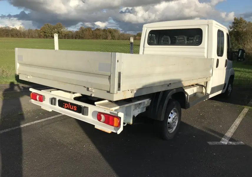 PEUGEOT Boxer Chassis Double Cabine blanc vu en 3/4 arrière droit avec plateau et cabine 7 places visible.