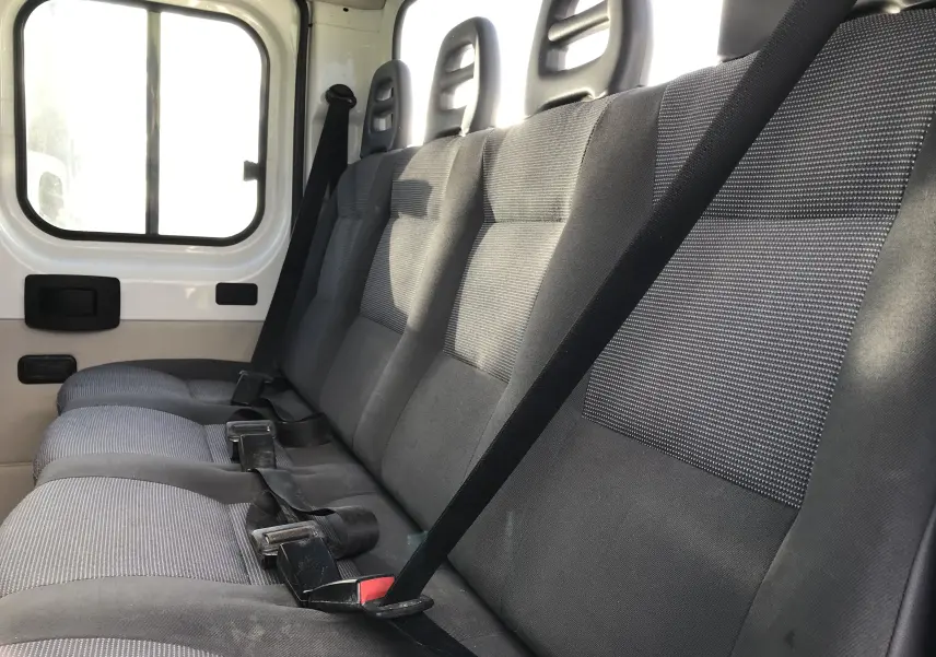 Vue intérieure côté droit des sièges arrière gris du Peugeot Boxer Chassis Double Cabine blanc de 2014, version 7 places.