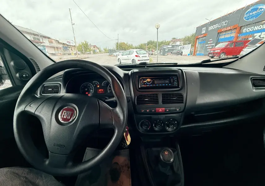 Vue intérieure du tableau de bord et volant du Fiat Doblo Cargo 2011, avec commande manuelle et autoradio visible.