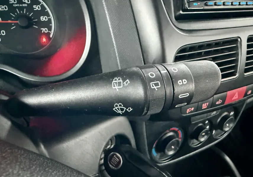 Gros plan sur la commande d’essuie-glace côté gauche du tableau de bord intérieur du Fiat Doblo Cargo rouge de 2011.