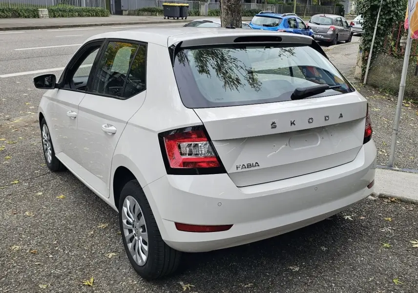 Vue 3/4 arrière gauche d'une Skoda Fabia blanche Cristal avec feux arrière LED et enjoliveurs de roue 15 pouces.