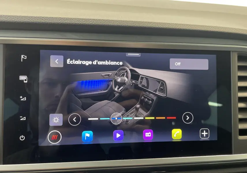 Écran tactile affichant l'intérieur du SEAT Ateca 2024 avec ambiance lumineuse bleue côté gauche et console centrale.