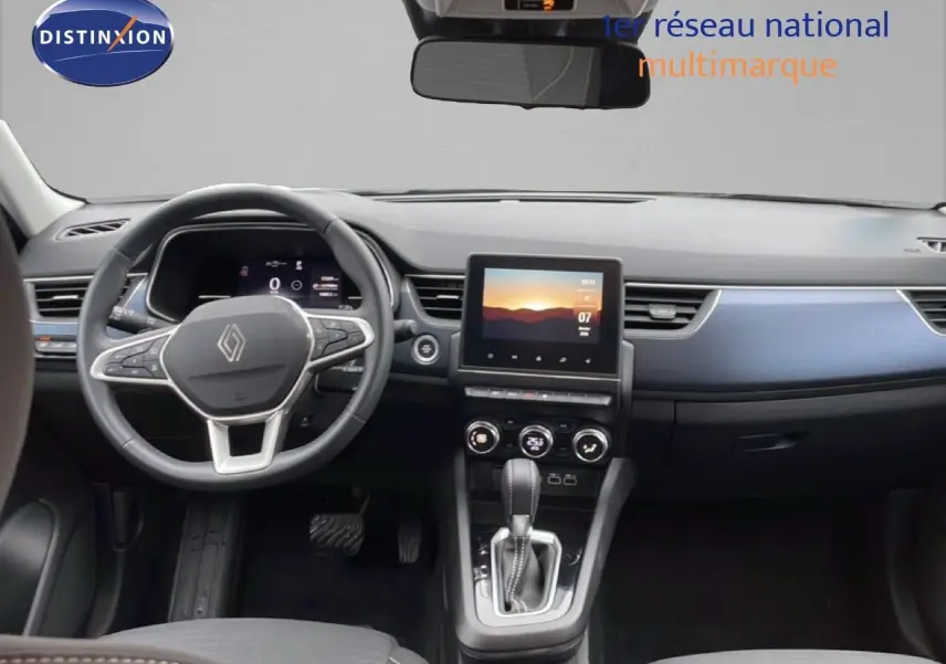 Vue intérieure avant du Renault Arkana 2025 avec tableau de bord noir et insert bleu Zanzibar Metal, écran tactile central et volant multifonction.