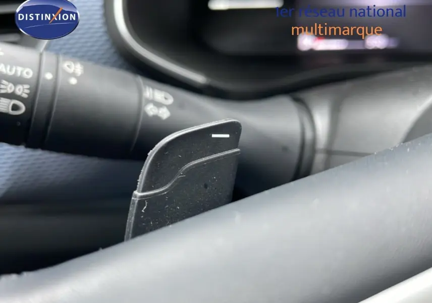 Gros plan sur la palette de changement de vitesse derrière le volant d’un Renault Arkana 2025, intérieur noir.