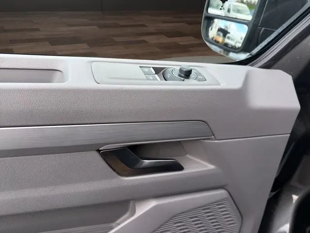 Détail de la porte côté conducteur du Volkswagen Transporter ProCab gris, avec commandes des rétroviseurs et poignée noire.