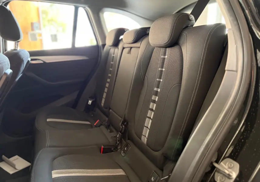 Vue intérieure côté droit des sièges arrière en tissu noir avec motifs gris d’un BMW X1 noir de 2018.