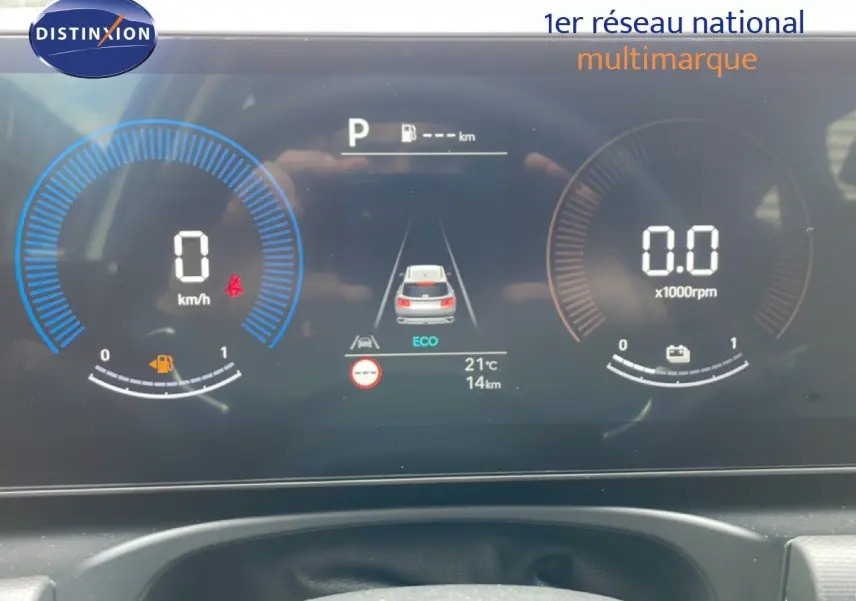 Tableau de bord numérique du Hyundai Tucson blanc, affichant vitesse, régime moteur et mode éco en vue frontale.