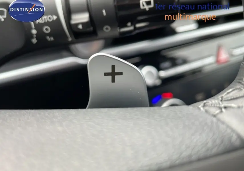 Gros plan sur la palette de changement de vitesse "+" côté droit du volant du Hyundai Tucson blanc Atlas 2026.