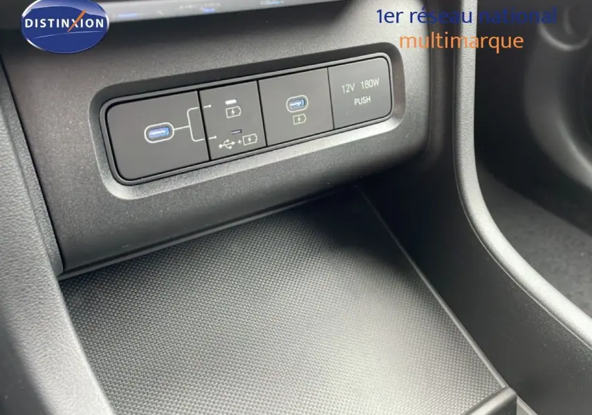 Gros plan sur la console centrale du Hyundai Tucson blanc Atlas 2026, montrant les ports USB et prise 12V.