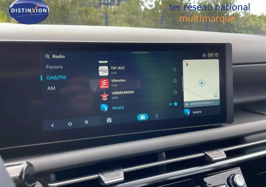 Écran tactile central du tableau de bord du Hyundai Tucson blanc, affichant les options radio et la navigation.