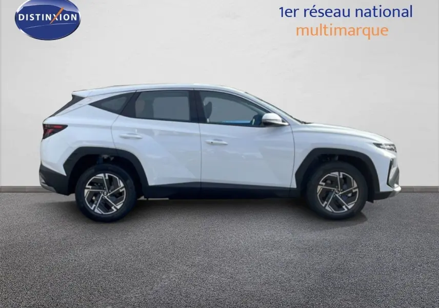 Vue de profil côté gauche d'un Hyundai Tucson blanc atlas 2026 avec jantes alliage et lignes anguleuses marquées.