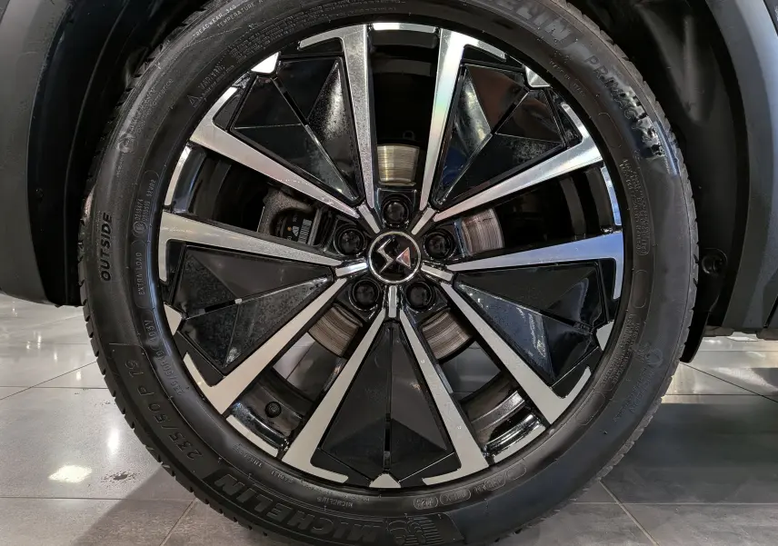 Gros plan sur la jante bi-ton noire et argentée du DS7 BlueHDi 130 gris, mettant en valeur le logo DS au centre.