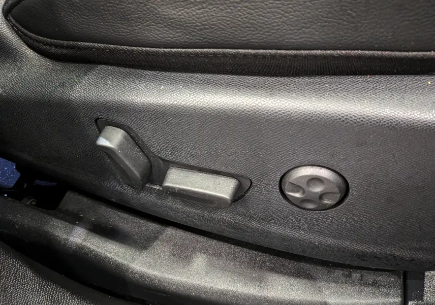 Détail des commandes de réglage électrique du siège en cuir noir dans le DS7 BlueHDi 2024.