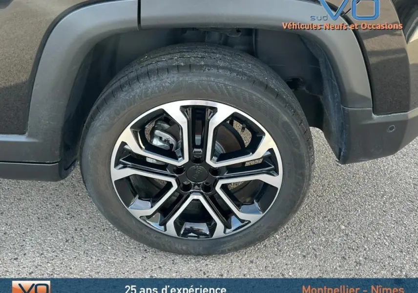 Gros plan sur la roue avant gauche du Jeep Compass noir 2024 avec jante alliage 18 pouces bicolore.