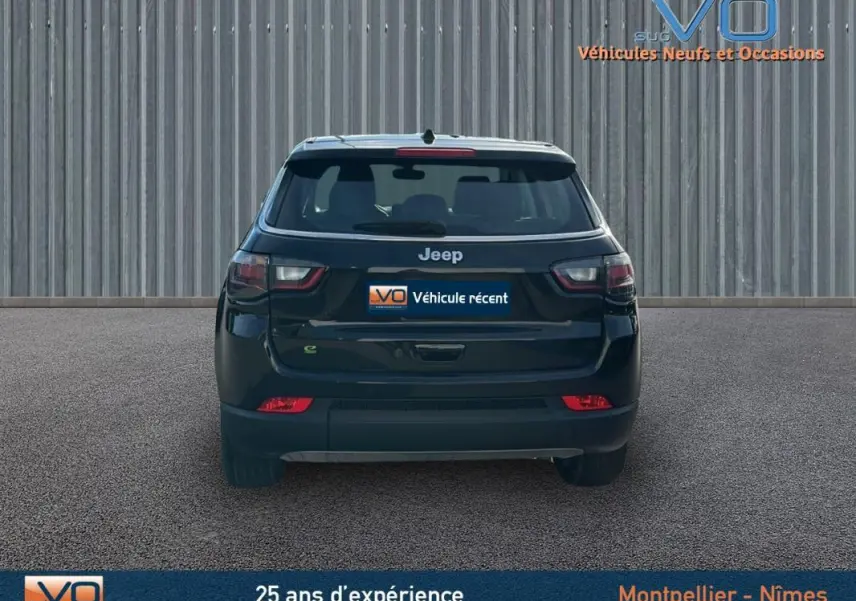 Vue arrière d'un Jeep Compass noir 2024 avec feux LED et logo Jeep bien visible sur un sol goudronné.