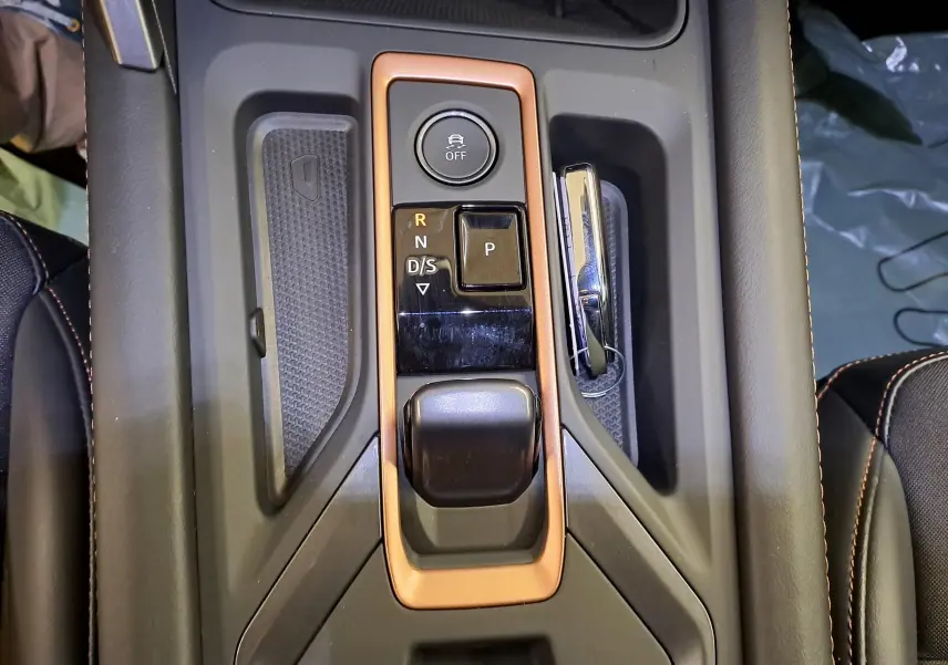 Vue rapprochée de la console centrale de la CUPRA Leon Ph.2 avec levier de boîte auto entouré d’un cadre cuivré.