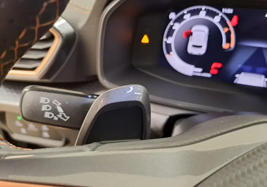 Gros plan sur la commande de clignotant et le tableau de bord numérique du CUPRA Leon Ph.2 noir Minuit, intérieur moderne