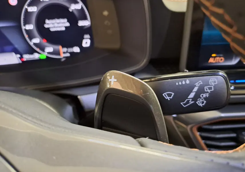 Gros plan sur la palette de changement de vitesse droite et le commodo d'essuie-glace dans l'habitacle du CUPRA Leon Noir Minuit.