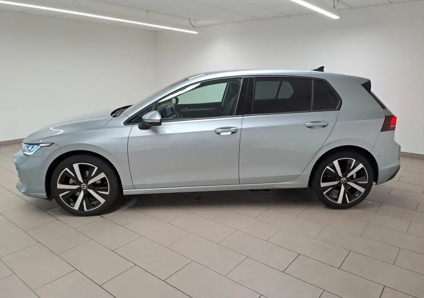 Vue de profil côté gauche d'une Volkswagen Golf 1.5 TSI 116 BVM6 VW Edition argent Dolomite avec jantes alliage 18 pouces Catania.