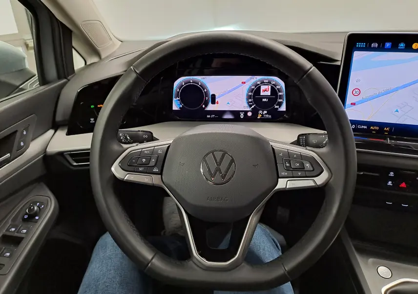 Vue intérieure centrée sur le volant noir de la Volkswagen Golf 1.5 TSI 2025 avec tableau de bord numérique et écran tactile.