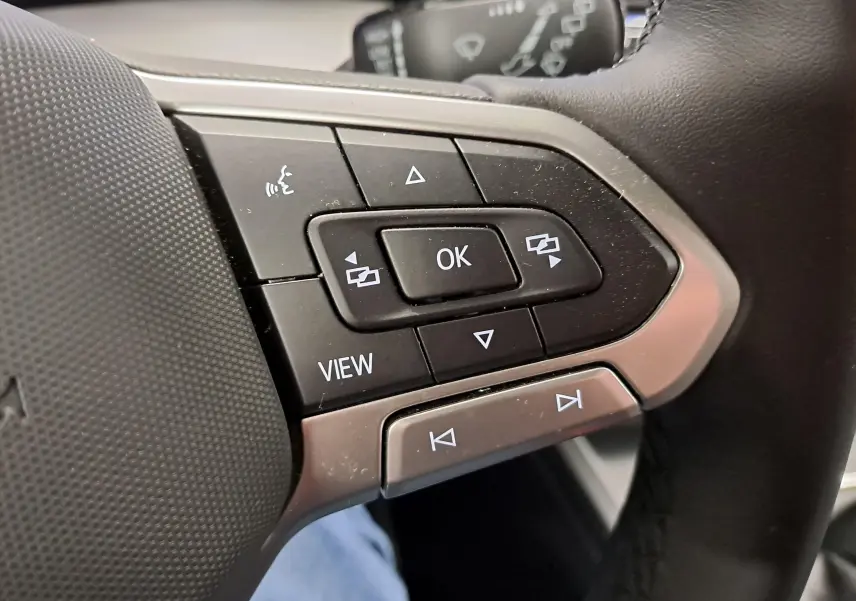 Gros plan sur les commandes multifonctions au volant côté gauche d'une Volkswagen Golf 1.5 TSI 2025.