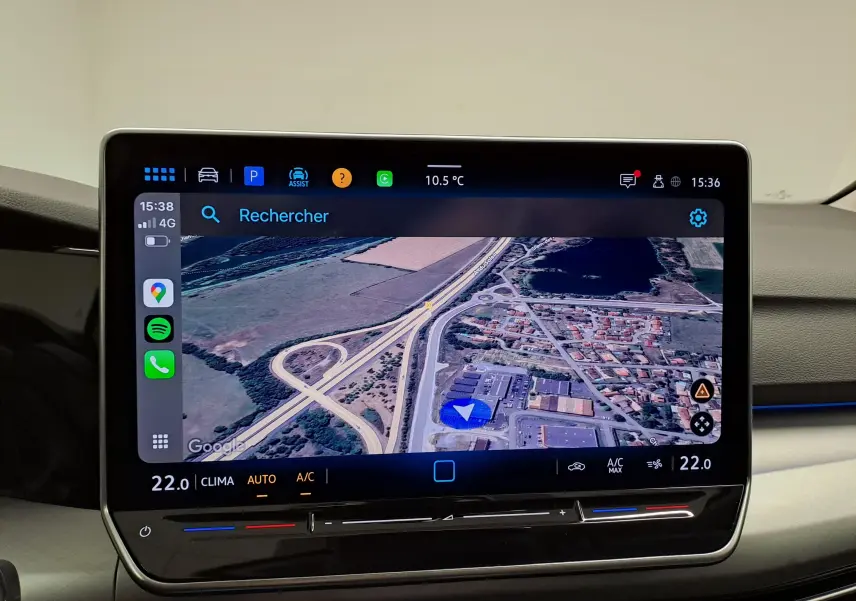 Écran tactile central de la Volkswagen Golf 2025 affichant la navigation GPS avec interface moderne et commandes climatisation intégrées.