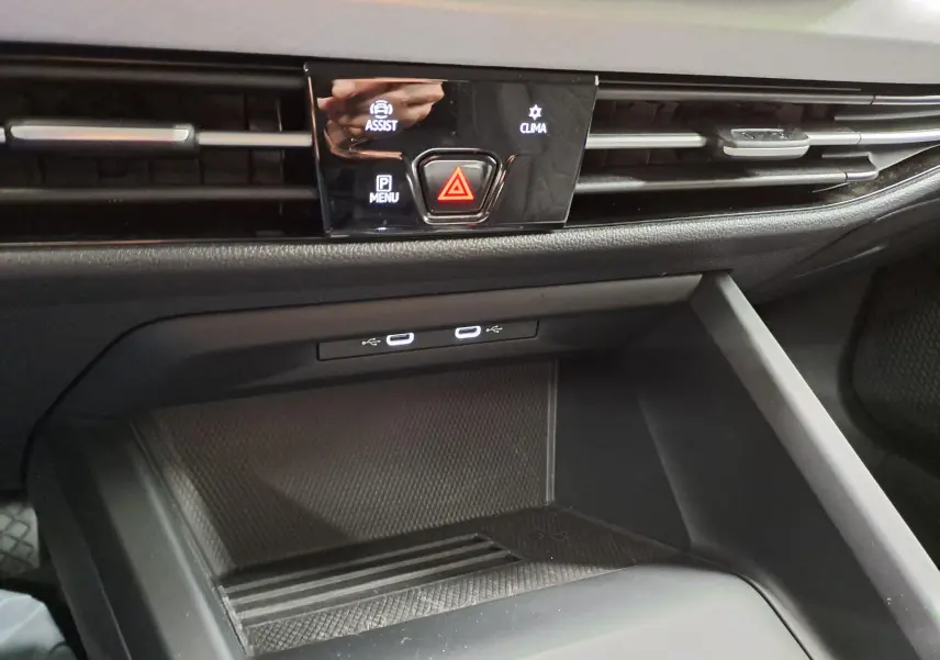 Gros plan sur la console centrale de la Volkswagen Golf 1.5 TSI 2025, montrant les commandes d’assistance, climatisation et ports USB.