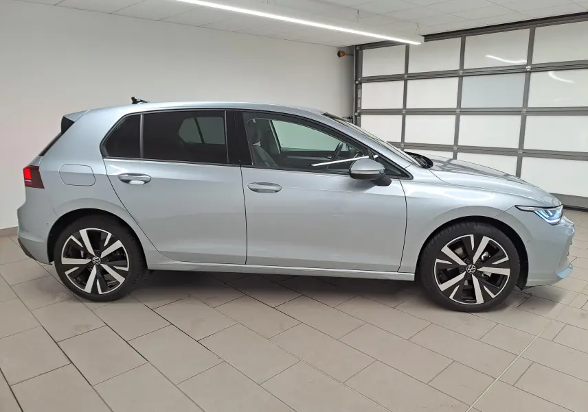 Vue de profil côté gauche d'une Volkswagen Golf 1.5 TSI 116 BVM6 VW Edition argent Dolomite avec jantes alliage 18 pouces.