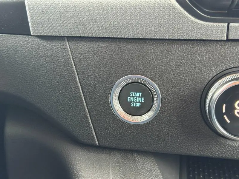 Gros plan sur le bouton Start Engine Stop du tableau de bord noir du Nissan Townstar L1 EV 2024 Blanc Minéral.