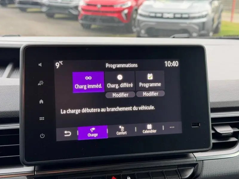 Écran tactile central du Nissan Townstar blanc, affichant les options de programmation de charge électrique, vue intérieure frontale.