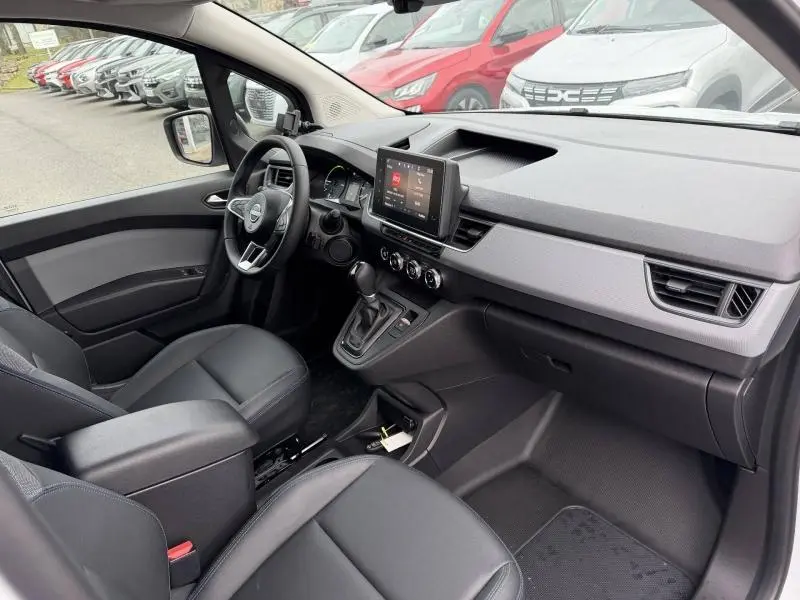 Vue intérieure côté conducteur du Nissan Townstar L1 EV 2024, tableau de bord moderne avec écran tactile et sièges noirs.