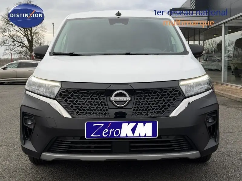Vue avant frontale du Nissan Townstar blanc minéral avec calandre noire et phares LED allumés.