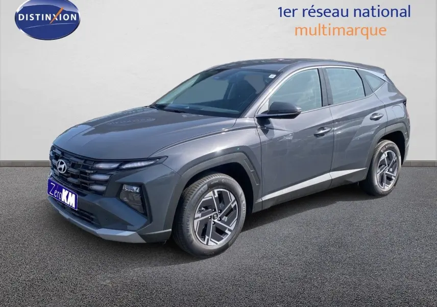 Hyundai Tucson gris Ecotronic Metal en 3/4 avant droit, SUV hybride avec jantes bi-ton et calandre marquée.