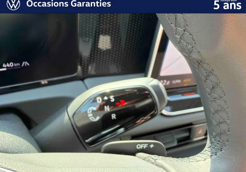 Gros plan sur le levier de vitesses noir brillant d’un Volkswagen Tiguan gris, avec affichage des modes de conduite.