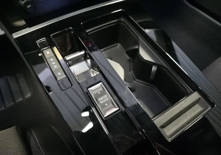 Gros plan sur la console centrale noire brillante de l’Opel Astra Hybrid 2024 avec sélecteur de mode de conduite.