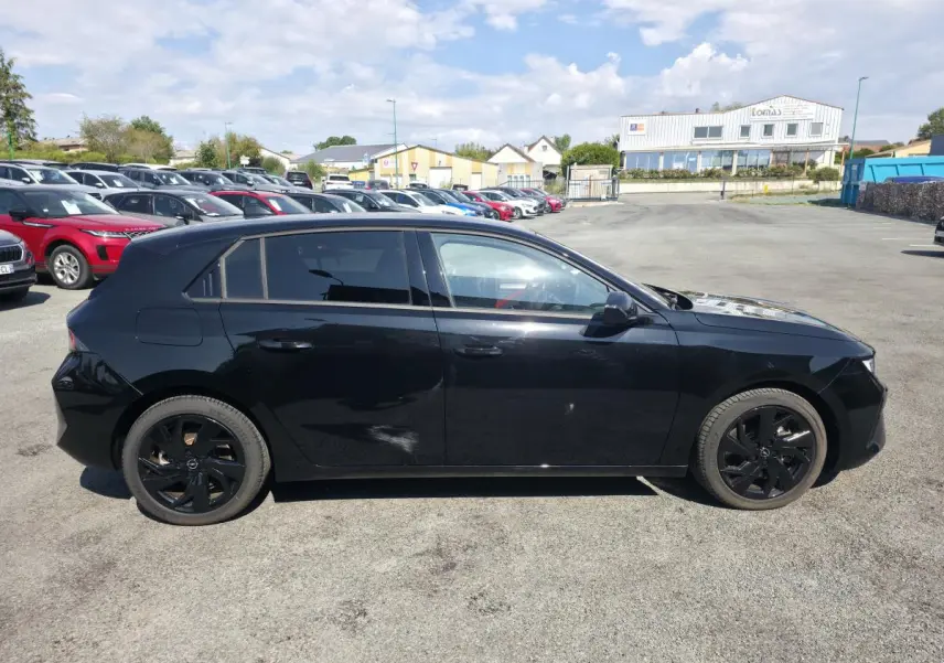 Opel Astra Hybrid 2024 noir vue de profil côté gauche avec jantes alliage noires et vitres surteintées.