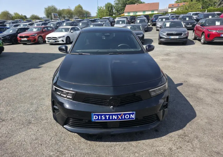 Vue avant d'une Opel Astra Hybrid 2024 noire avec calandre noire et jantes alliage 17 pouces sur parking.