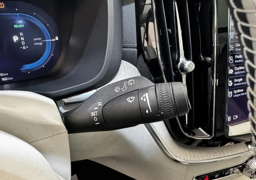 Gros plan sur la manette d’essuie-glace côté gauche du tableau de bord du Volvo XC60 bleu hybride rechargeable.