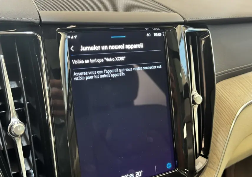 Écran tactile central affichant jumelage Bluetooth dans l’habitacle beige et noir du Volvo XC60 bleu.