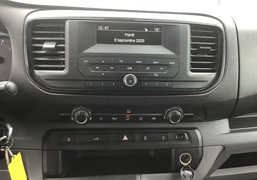 Tableau de bord noir de l'Opel Vivaro blanc 2022, vue centrale sur la console avec écran et commandes climatisation.