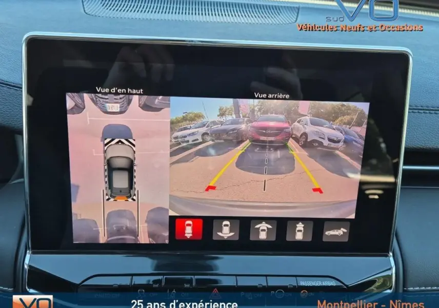 Écran tactile intérieur montrant la caméra de recul et vue aérienne du Jeep Compass gris 2024 en stationnement.