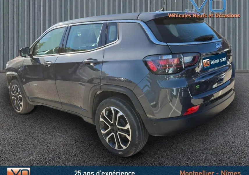 Vue 3/4 arrière droite d'un Jeep Compass gris 2024 avec jantes alliage 18 pouces et vitres teintées.