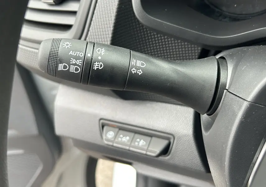 Gros plan sur la manette de commande des phares et clignotants du Renault Trafic Combi L2 Grand Evolution blanc.