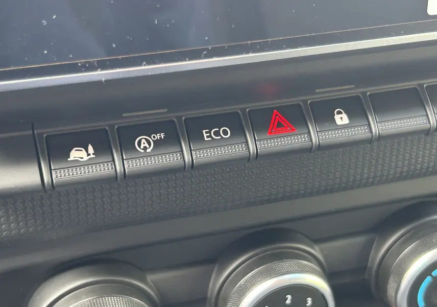 Gros plan sur les boutons de commande du tableau de bord du Renault Trafic Combi L2 Grand Evolution 2025, avec bouton ECO et alerte.